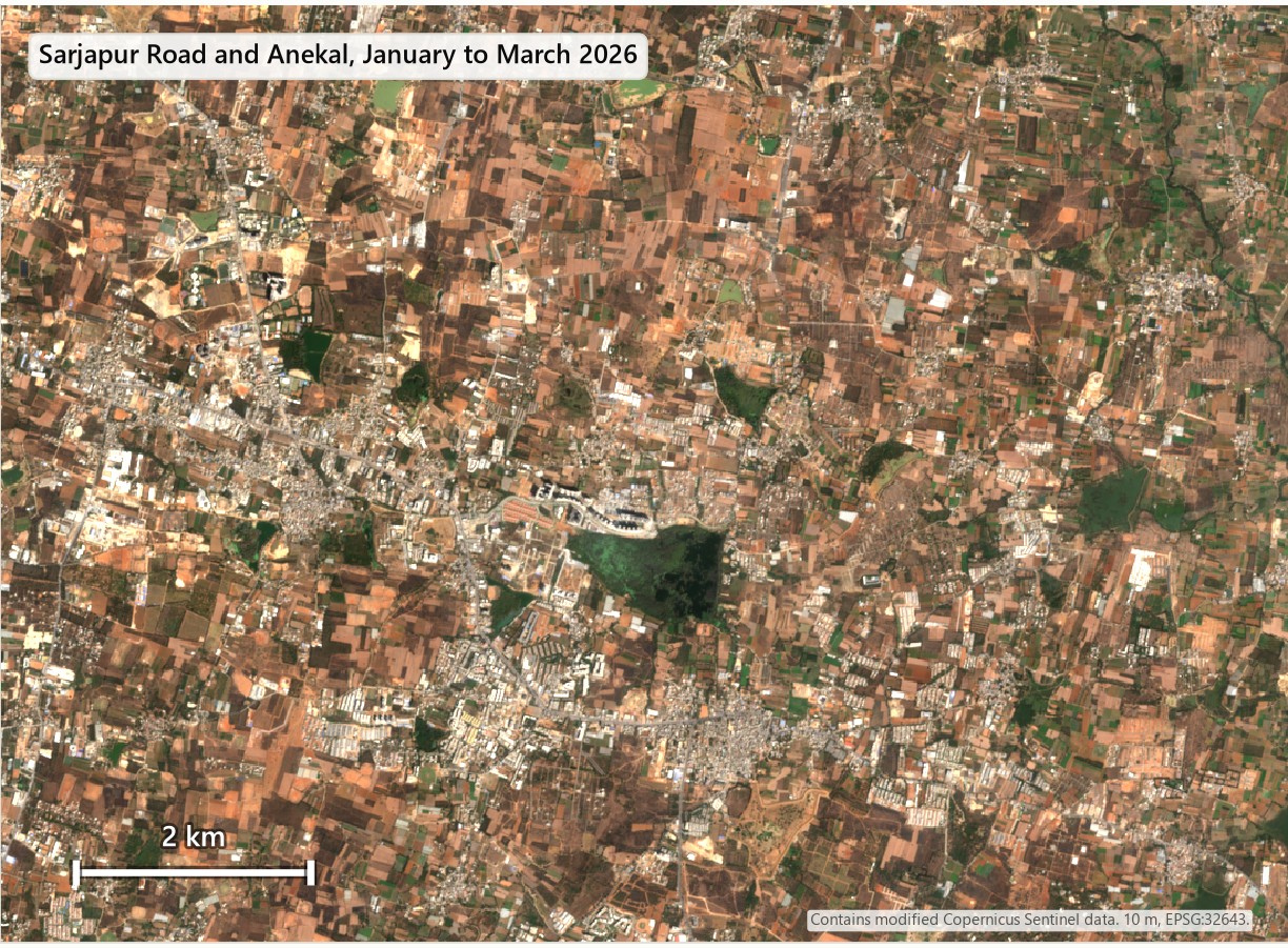 Satellite view south-east of Bengaluru: scattered housing and fields in 2018, denser grey blocks along the road in 2026.